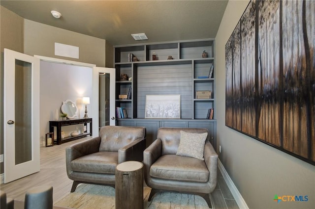 living area with light wood-type flooring and a textured ceiling