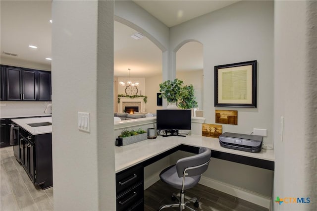 home office featuring an inviting chandelier and built in desk