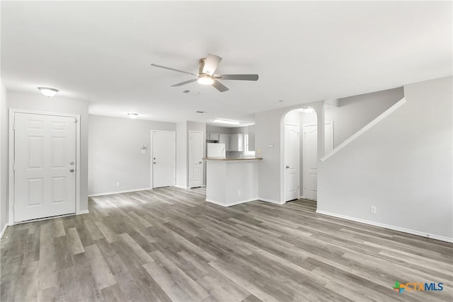 9538 Beau Brg, San Antonio, TX 78254 - unfurnished living room with a ceiling fan, arched walkways, and wood finished floors