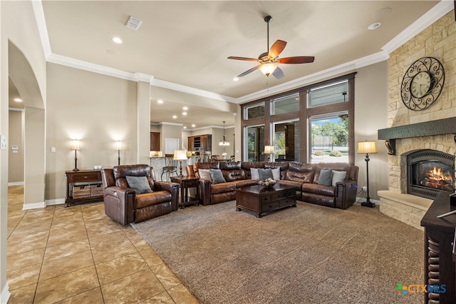 tiled living room with a fireplace, ceiling fan, and crown molding