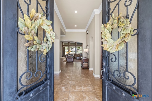 tiled foyer featuring ornamental molding