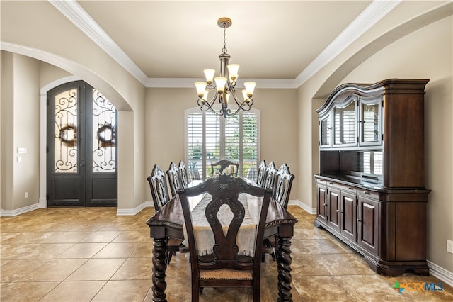 dining space with a wealth of natural light, ornamental molding, french doors, and a notable chandelier