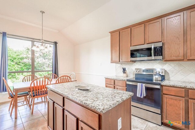5821 Worthing Dr, Temple, TX 76502 - kitchen with appliances with stainless steel finishes, vaulted ceiling, a kitchen island, tasteful backsplash, and light stone counters