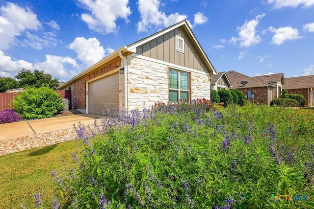 5821 Worthing Dr, Temple, TX 76502 - view of property exterior with board and batten siding, an attached garage, stone siding, and concrete driveway