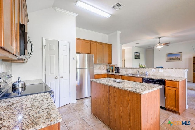 5821 Worthing Dr, Temple, TX 76502 - kitchen featuring stainless steel appliances, a peninsula, a kitchen island, backsplash, and light tile patterned flooring