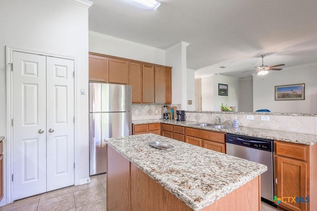5821 Worthing Dr, Temple, TX 76502 - kitchen featuring appliances with stainless steel finishes, backsplash, a ceiling fan, a peninsula, and light stone countertops