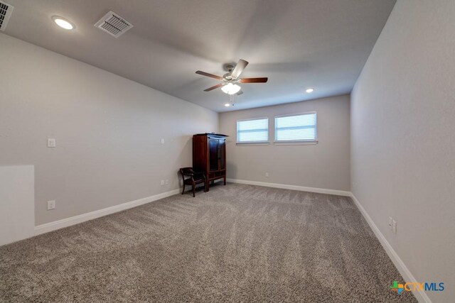 carpeted spare room featuring ceiling fan