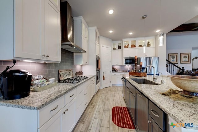 kitchen with white cabinetry and wall chimney range hood