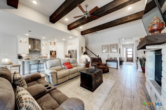 living room featuring beamed ceiling and ceiling fan