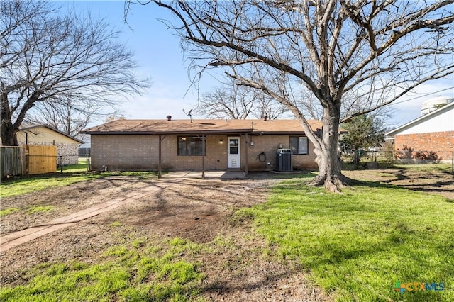 rear view of house with cooling unit and a lawn