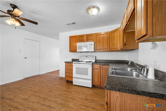 kitchen with sink, ceiling fan, white appliances, and light hardwood / wood-style flooring