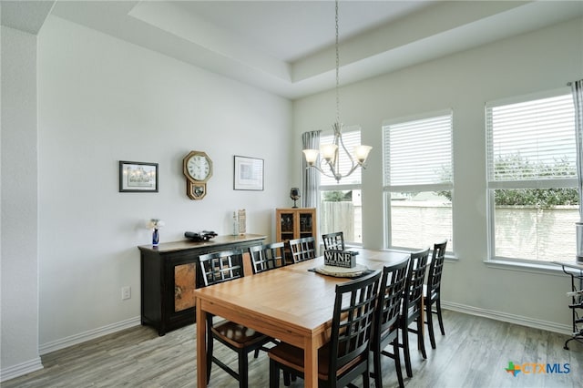 19500 Chayton Cir, Pflugerville, TX 78660 - dining area featuring light wood-style flooring, a chandelier, baseboards, and a tray ceiling