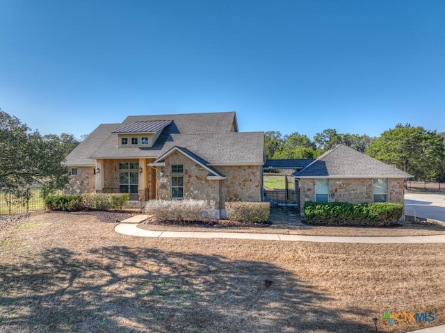 view of front of house with stone siding and fence