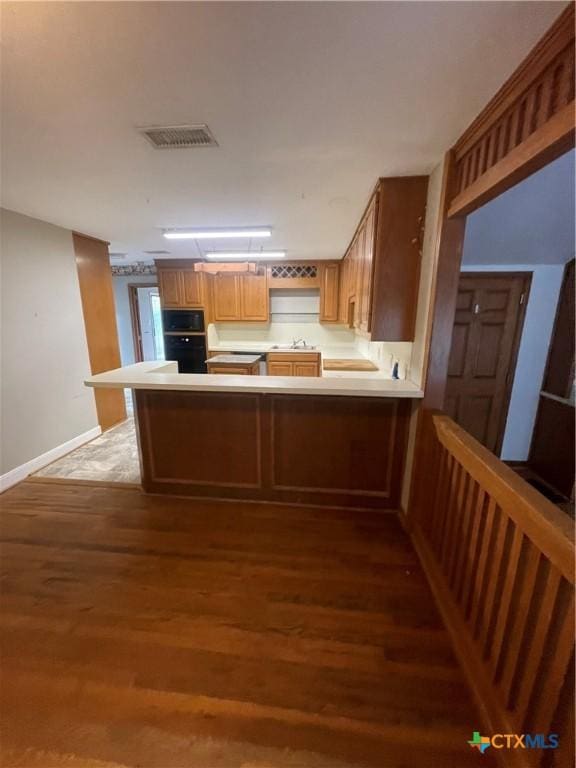 1505 E Park Ave, Victoria, TX 77901 - kitchen with oven, built in microwave, a peninsula, and wood finished floors