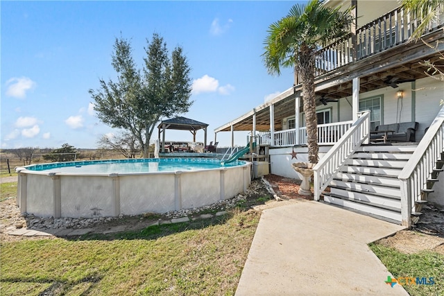 view of swimming pool with a gazebo and ceiling fan