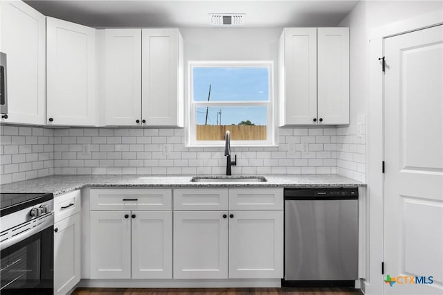 kitchen featuring visible vents, appliances with stainless steel finishes, white cabinets, and a sink