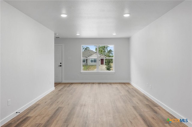 empty room with baseboards and wood finished floors