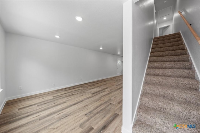 stairway with baseboards, wood finished floors, and recessed lighting