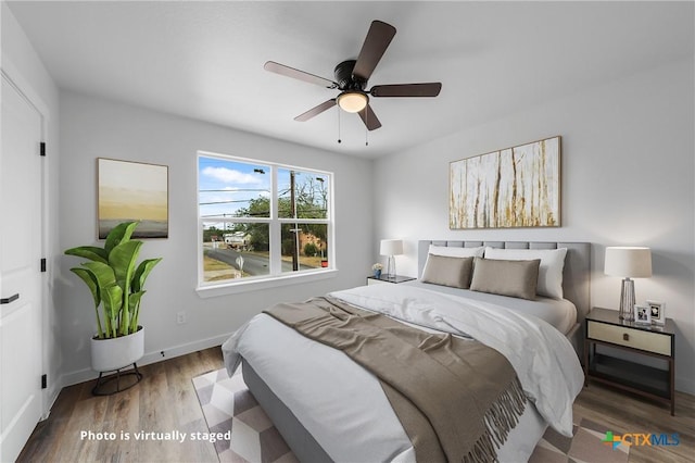 bedroom featuring a ceiling fan, baseboards, and wood finished floors