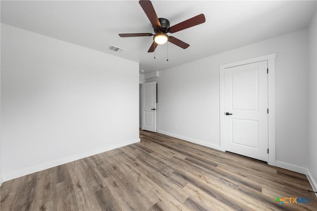 interior space featuring baseboards, visible vents, and wood finished floors