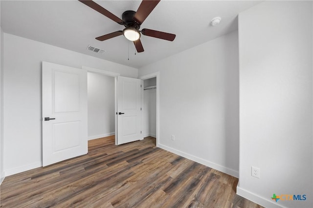 unfurnished bedroom with baseboards, visible vents, a ceiling fan, wood finished floors, and a closet