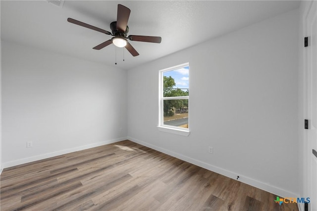 unfurnished room with ceiling fan, baseboards, and wood finished floors