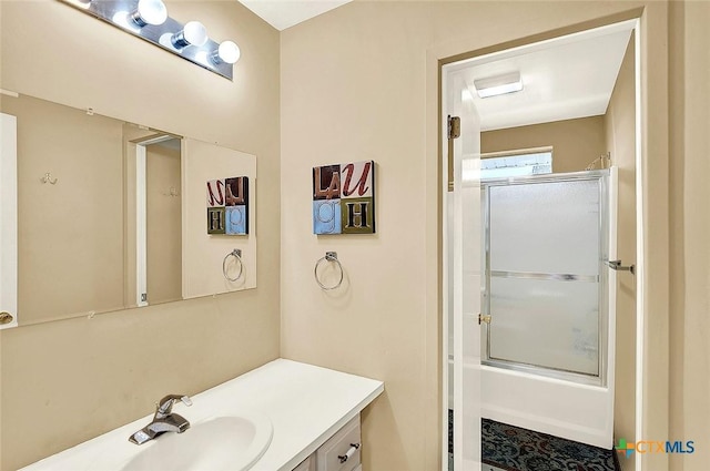bathroom with shower / bath combination with glass door and vanity