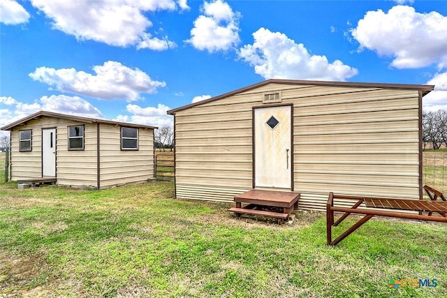 view of outbuilding featuring fence and an outbuilding