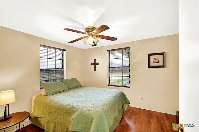 bedroom featuring ceiling fan, baseboards, and wood finished floors