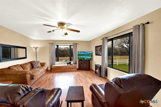 living room featuring light wood-style floors and ceiling fan