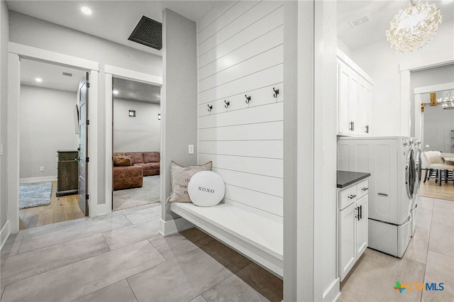 bathroom with an inviting chandelier, tile patterned floors, and independent washer and dryer