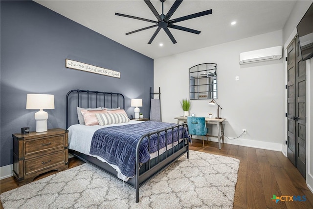 bedroom with wood-type flooring, an AC wall unit, and ceiling fan