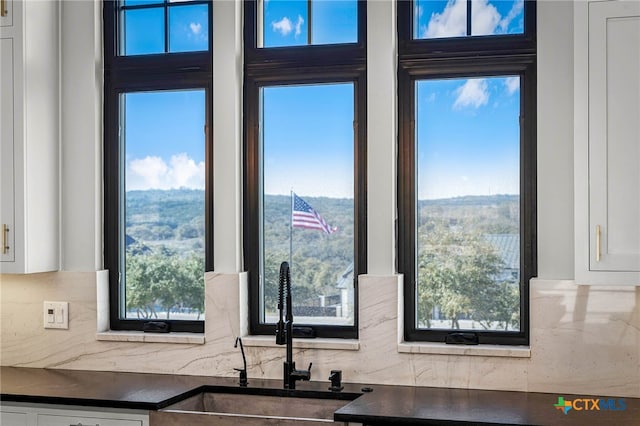 kitchen with white cabinetry, sink, and tasteful backsplash