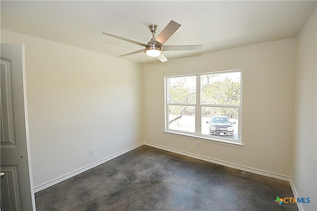 spare room with ceiling fan and baseboards