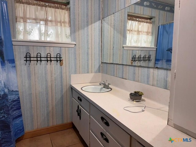 2708 E Poplar Ave, Victoria, TX 77901 - bathroom with wallpapered walls, vanity, and tile patterned flooring