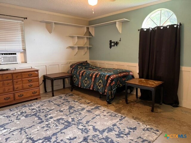 2708 E Poplar Ave, Victoria, TX 77901 - bedroom featuring a decorative wall, cooling unit, a wainscoted wall, a textured ceiling, and ornamental molding