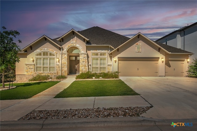 view of front of property with a yard and a garage