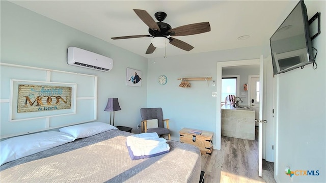 1265 N Ocean Dr Unit 2, Port Lavaca, TX 77979 - bedroom featuring a wall mounted AC, wood finished floors, and a ceiling fan