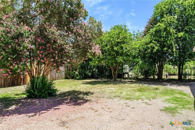 back of house featuring a carport and a yard