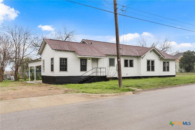 view of front facade with a front lawn and a carport