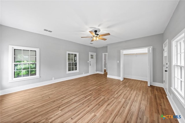 unfurnished bedroom with ceiling fan, light hardwood / wood-style flooring, and multiple windows