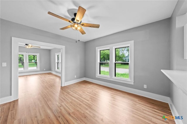 unfurnished living room with a wealth of natural light, ceiling fan, and light wood-type flooring