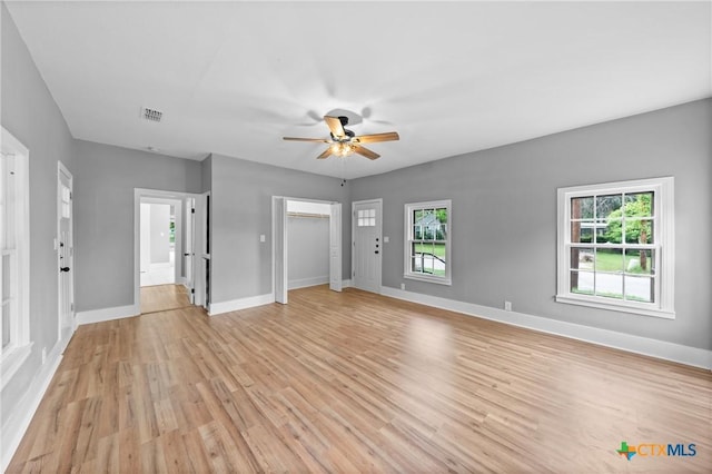 unfurnished living room with plenty of natural light, ceiling fan, and light hardwood / wood-style flooring