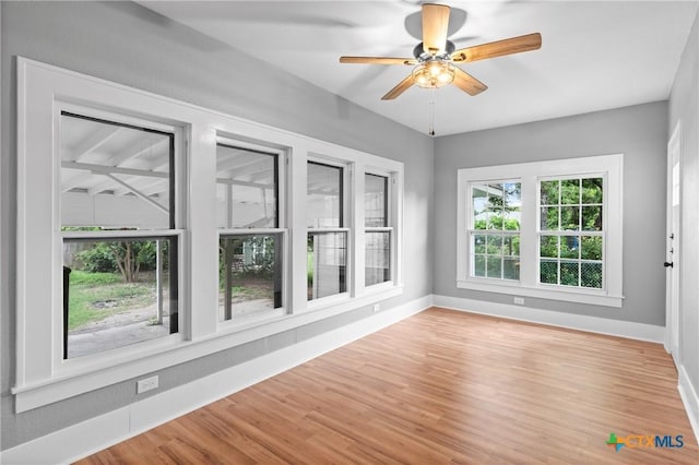 unfurnished sunroom with ceiling fan