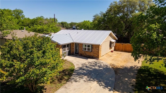 226 Gruene Rd, New Braunfels, TX 78130 - view of front of home featuring brick siding, driveway, metal roof, and fence
