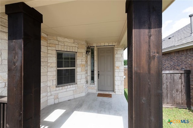 9505 Alex Ln, Austin, TX 78748 - doorway to property featuring stone siding and covered porch