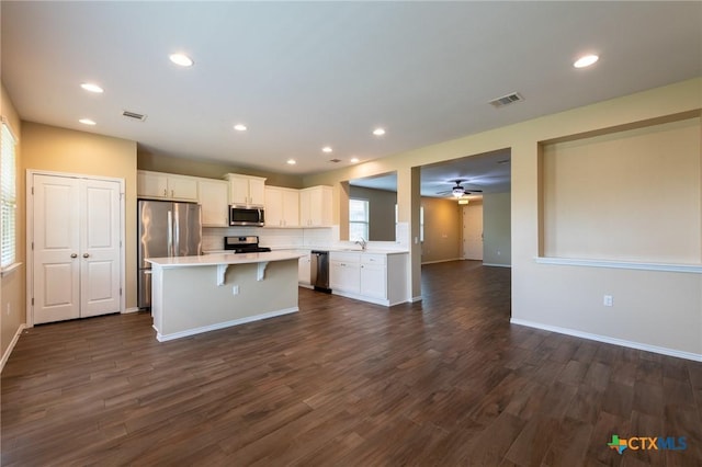 9505 Alex Ln, Austin, TX 78748 - kitchen featuring stainless steel appliances, a center island, open floor plan, white cabinetry, and light countertops