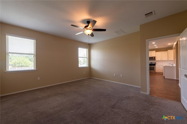 9505 Alex Ln, Austin, TX 78748 - spare room featuring ceiling fan and dark carpet