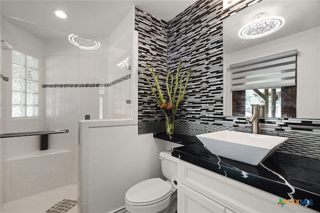 bathroom with toilet, tasteful backsplash, tiled shower, and plenty of natural light