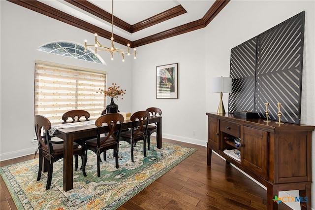 dining space featuring ornamental molding, a notable chandelier, dark hardwood / wood-style floors, and a raised ceiling